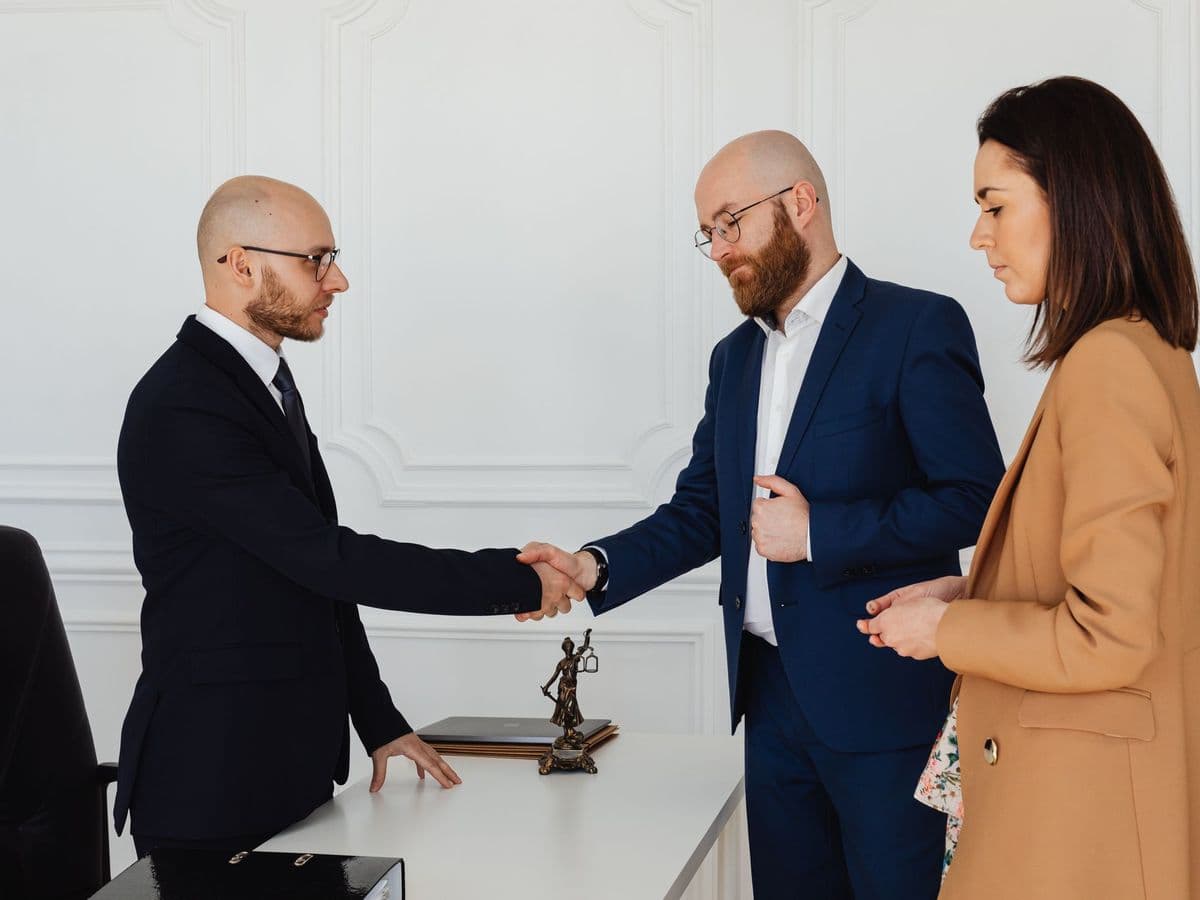 Consultor cumprimentando os clientes no fechamento da reunião